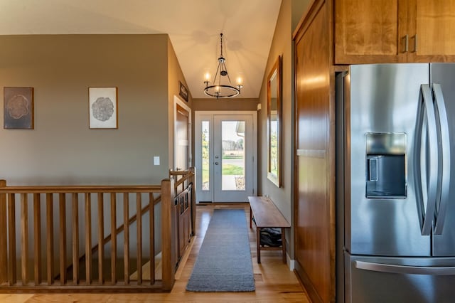 entryway with light wood-type flooring and a chandelier