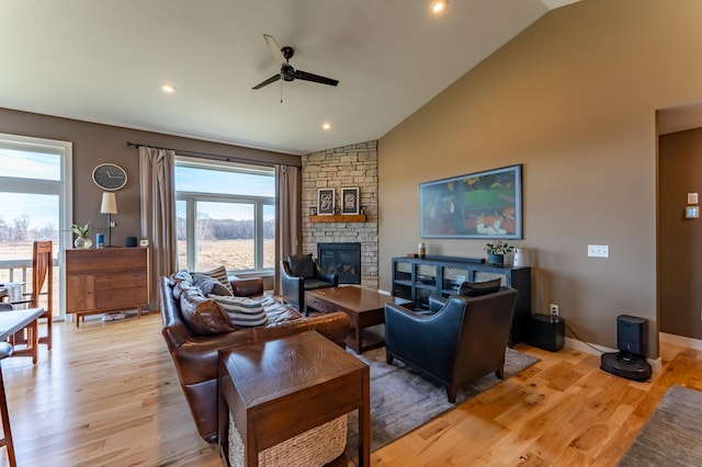 living room with a fireplace, vaulted ceiling, light hardwood / wood-style flooring, and ceiling fan