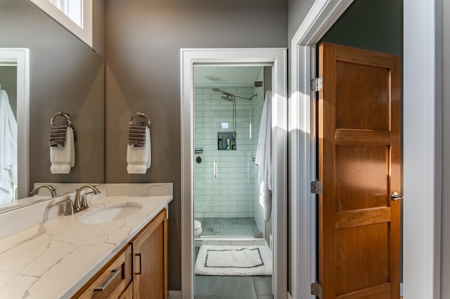 bathroom with a shower with door, vanity, and toilet