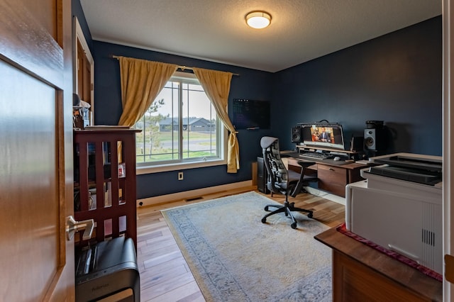 office space featuring a textured ceiling and light hardwood / wood-style floors