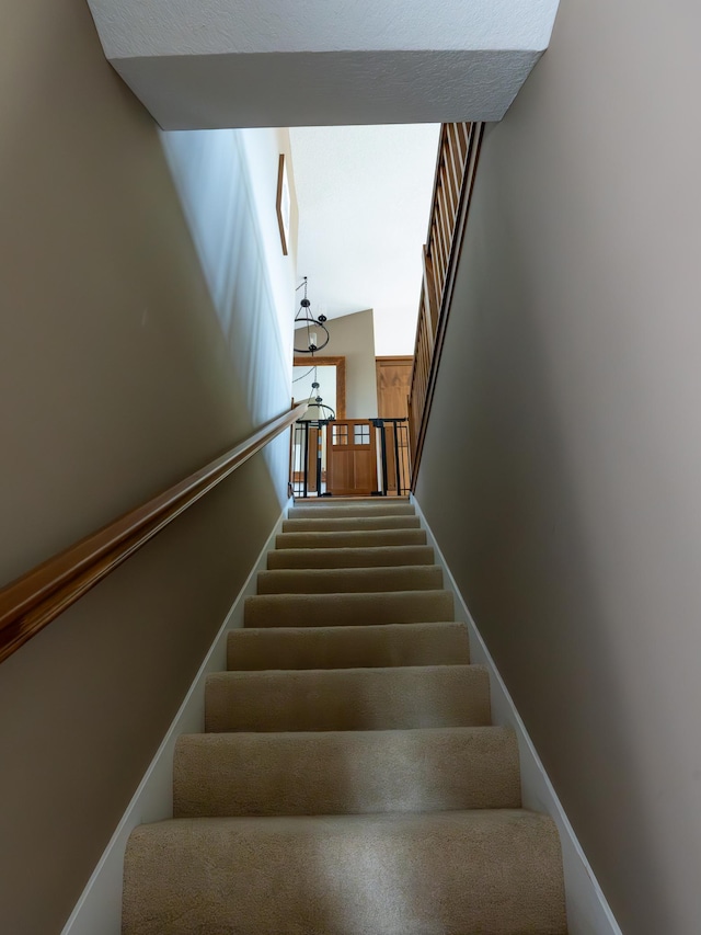 stairs with a notable chandelier