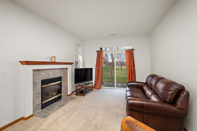 carpeted living room with a tiled fireplace