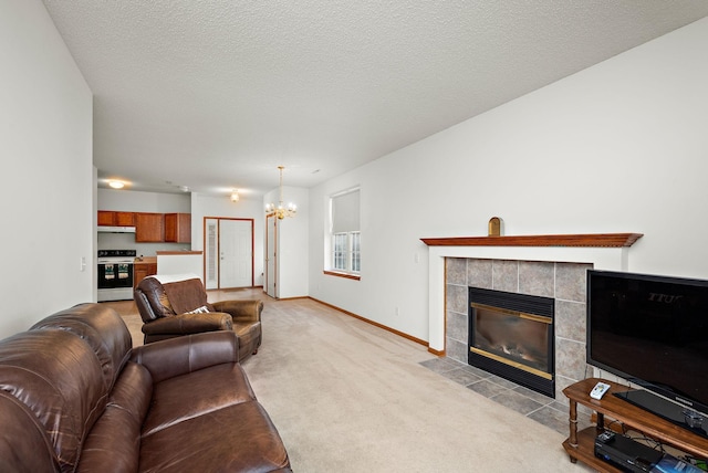 living room with a chandelier, a textured ceiling, light colored carpet, and a tiled fireplace