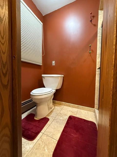 bathroom with tile patterned flooring, toilet, and baseboard heating