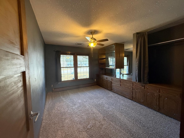 interior space with ceiling fan, a textured ceiling, light carpet, and a baseboard radiator