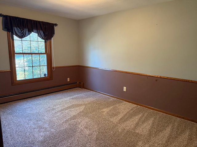 carpeted spare room featuring baseboard heating