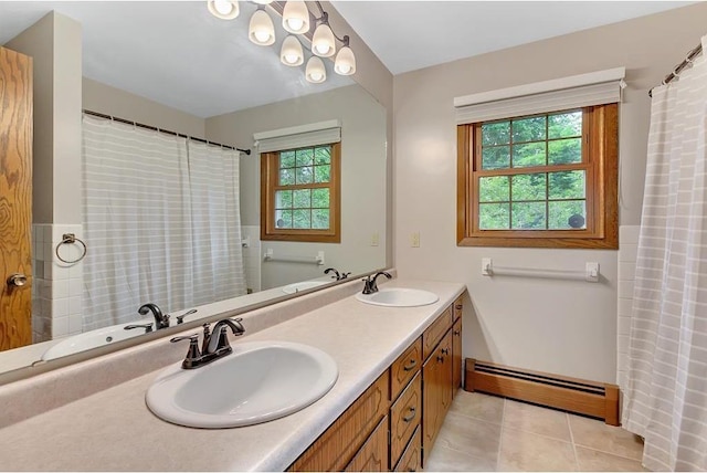 bathroom featuring a wealth of natural light, vanity, tile patterned floors, and baseboard heating