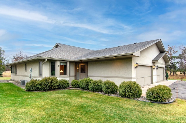 ranch-style home with a front lawn, cooling unit, and a garage