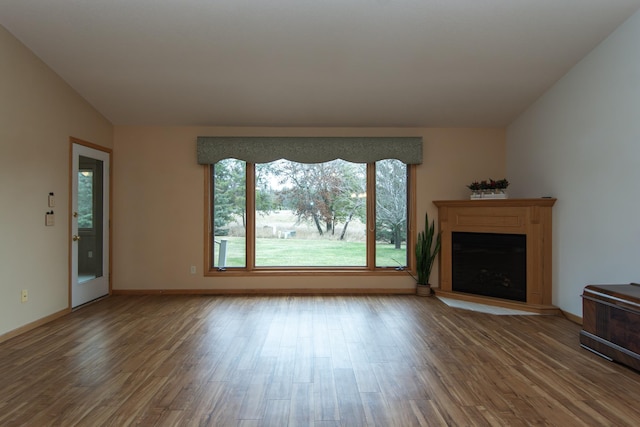 unfurnished living room with hardwood / wood-style floors and lofted ceiling