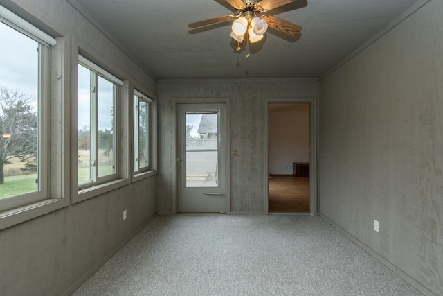 unfurnished sunroom featuring ceiling fan