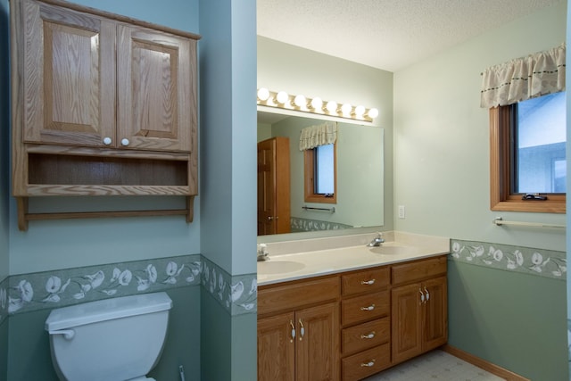 bathroom featuring vanity, a textured ceiling, and toilet