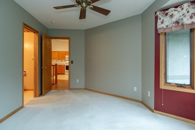 bedroom with ceiling fan, light carpet, and connected bathroom