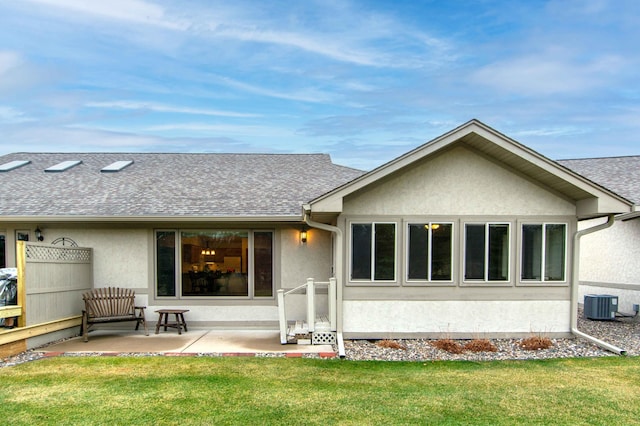 rear view of house with central air condition unit, a yard, and a patio