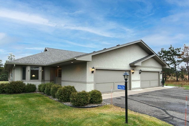 ranch-style house featuring a front yard and a garage