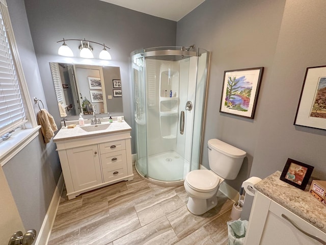 bathroom with vanity, hardwood / wood-style flooring, toilet, and an enclosed shower