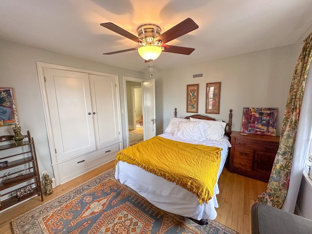 bedroom featuring ceiling fan, light wood-type flooring, and a closet