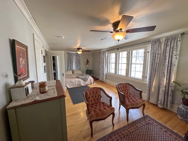 bedroom with ceiling fan, light hardwood / wood-style flooring, and a textured ceiling