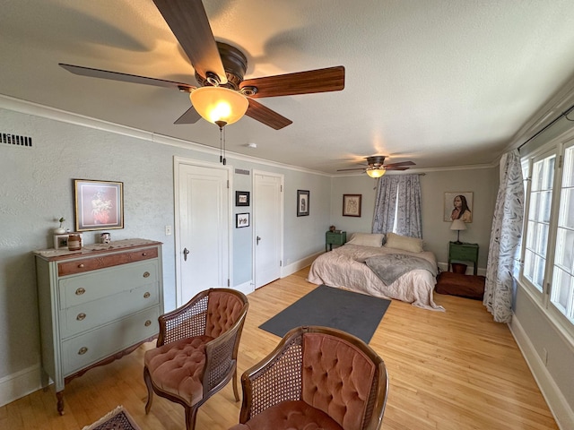 bedroom with light wood-type flooring, ceiling fan, and ornamental molding