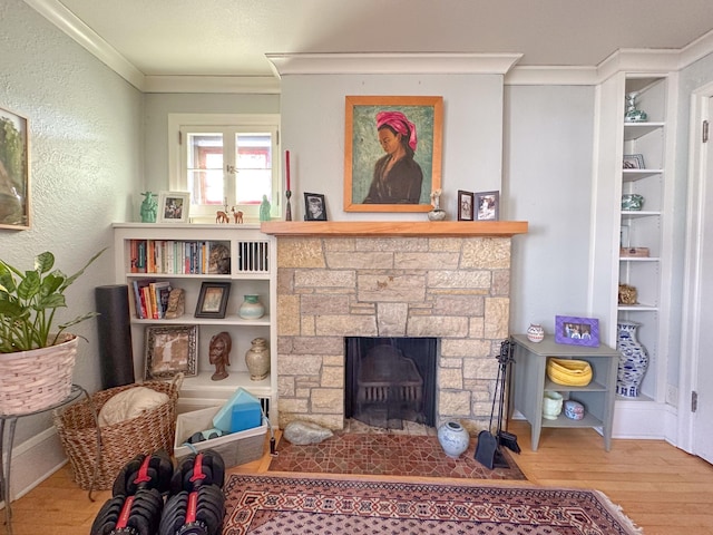 living area with a fireplace, hardwood / wood-style floors, and ornamental molding