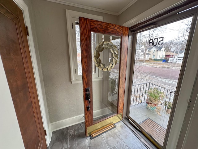 entryway with a textured wall, plenty of natural light, baseboards, and ornamental molding