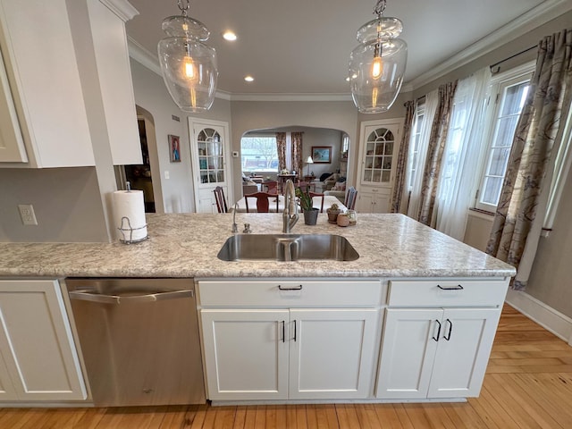 kitchen with dishwasher, arched walkways, a sink, crown molding, and white cabinetry