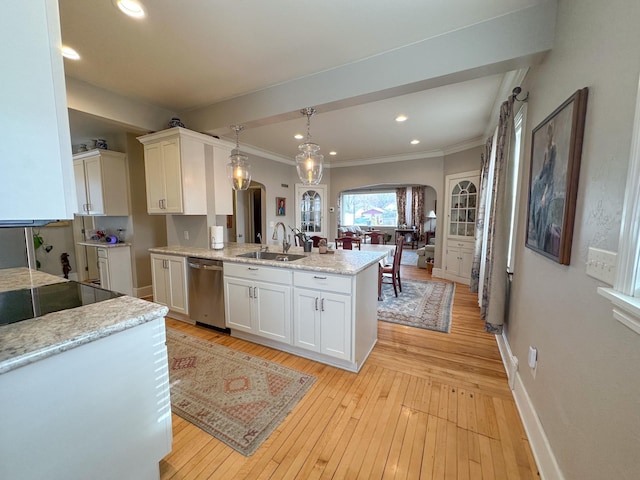 kitchen with arched walkways, a sink, stainless steel dishwasher, a peninsula, and white cabinetry