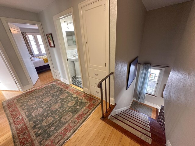 stairway featuring wood-type flooring, healthy amount of natural light, and baseboards