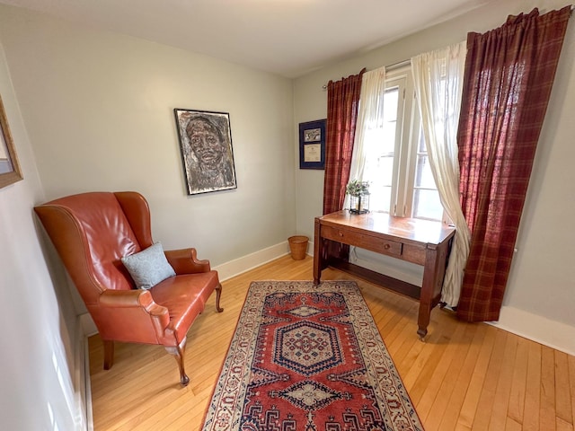 living area with light wood-style flooring and baseboards