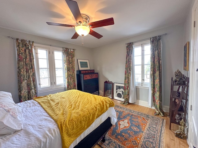 bedroom featuring wood finished floors, a ceiling fan, and baseboards