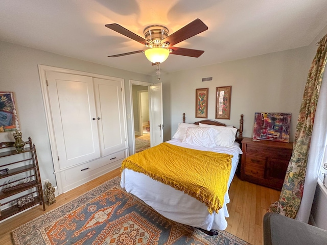 bedroom featuring light wood finished floors, a ceiling fan, and a closet