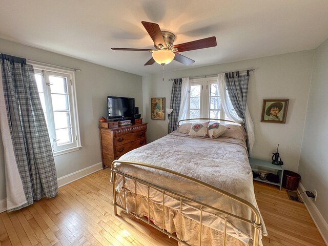 bedroom with light wood-style floors, baseboards, and a ceiling fan
