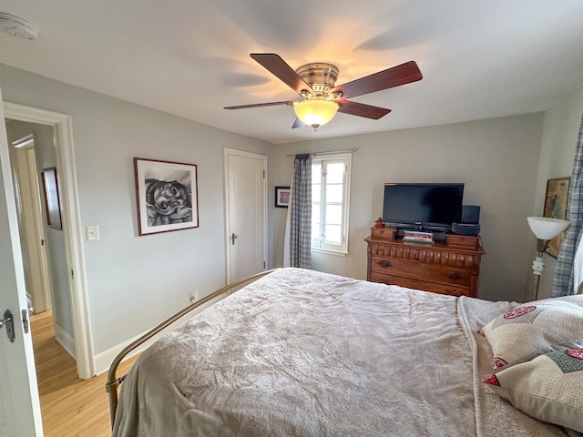 bedroom with light wood-style floors, baseboards, and a ceiling fan