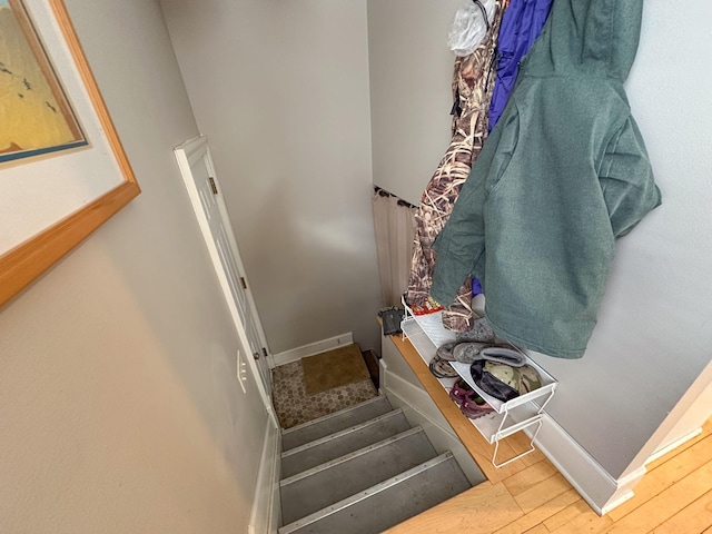 stairs with wood finished floors and baseboards