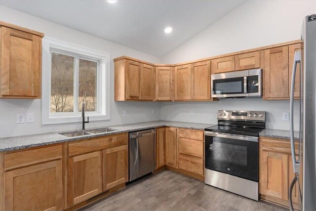 S1546 Shawnee Dr Unit B, Alma, WI 54610 - kitchen featuring stainless steel appliances, a sink, vaulted ceiling, wood finished floors, and light stone countertops