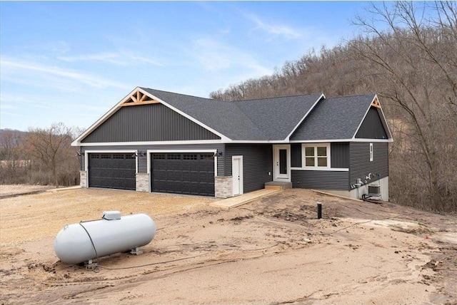 S1546 Shawnee Dr Unit B, Alma, WI 54610 - view of front of house featuring a shingled roof, driveway, a garage, and cooling unit