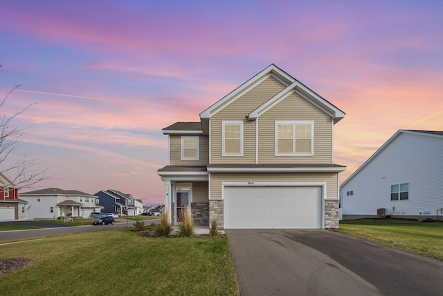 view of front of home featuring a garage and a lawn