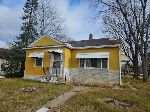 bungalow-style home with a front lawn