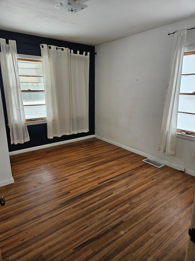 unfurnished room with dark hardwood / wood-style flooring