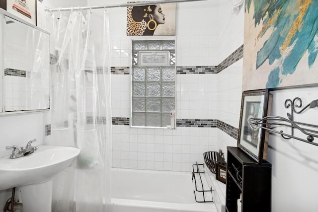 bathroom featuring shower / bath combination with curtain and sink