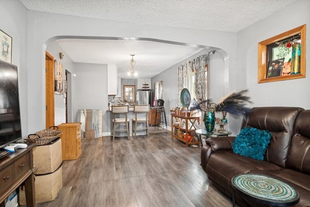 living room featuring a chandelier, a textured ceiling, and hardwood / wood-style flooring