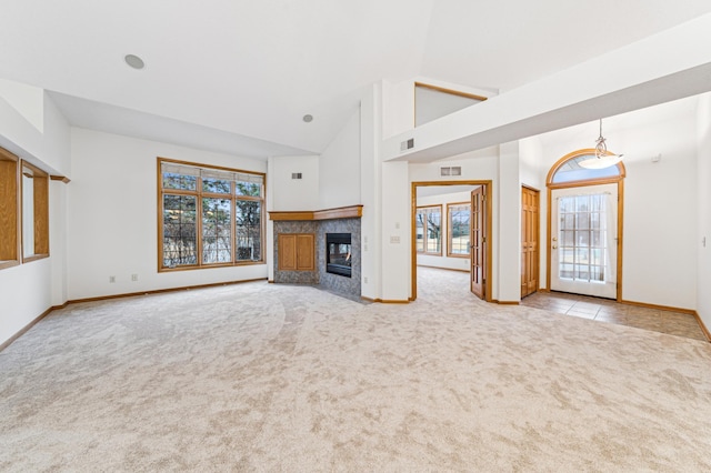 unfurnished living room featuring high vaulted ceiling, carpet floors, a fireplace, visible vents, and baseboards