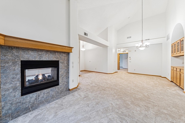 unfurnished living room with baseboards, visible vents, light carpet, and a multi sided fireplace