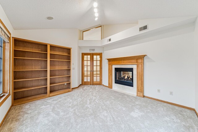 unfurnished living room with lofted ceiling, visible vents, a multi sided fireplace, and baseboards