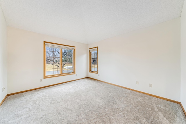 carpeted empty room featuring baseboards and a textured ceiling