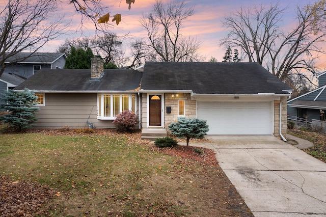 view of front of house featuring a garage and a lawn