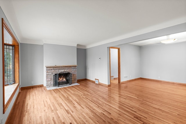 unfurnished living room featuring a fireplace and light hardwood / wood-style flooring