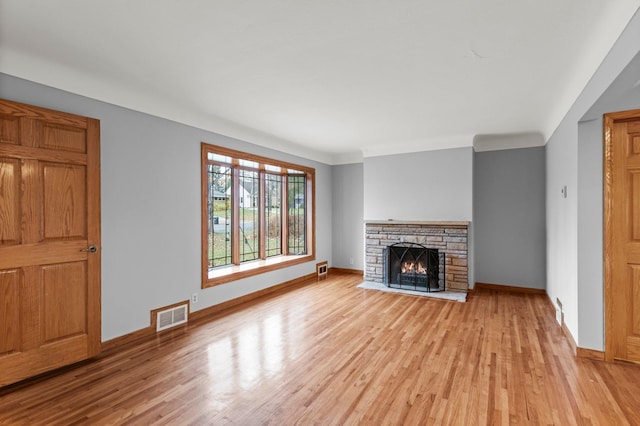 unfurnished living room featuring a fireplace, light hardwood / wood-style floors, and ornamental molding