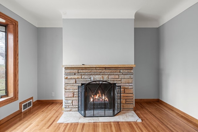 interior details featuring a stone fireplace and hardwood / wood-style floors