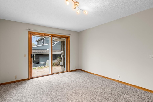 empty room with carpet flooring and a textured ceiling