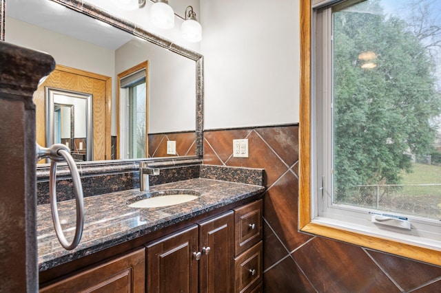 bathroom featuring vanity and tile walls